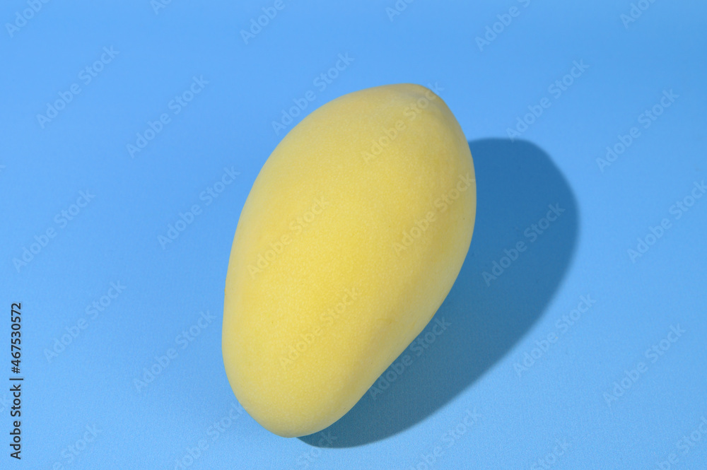 Ripe yellow mango fruit with a tough shadow