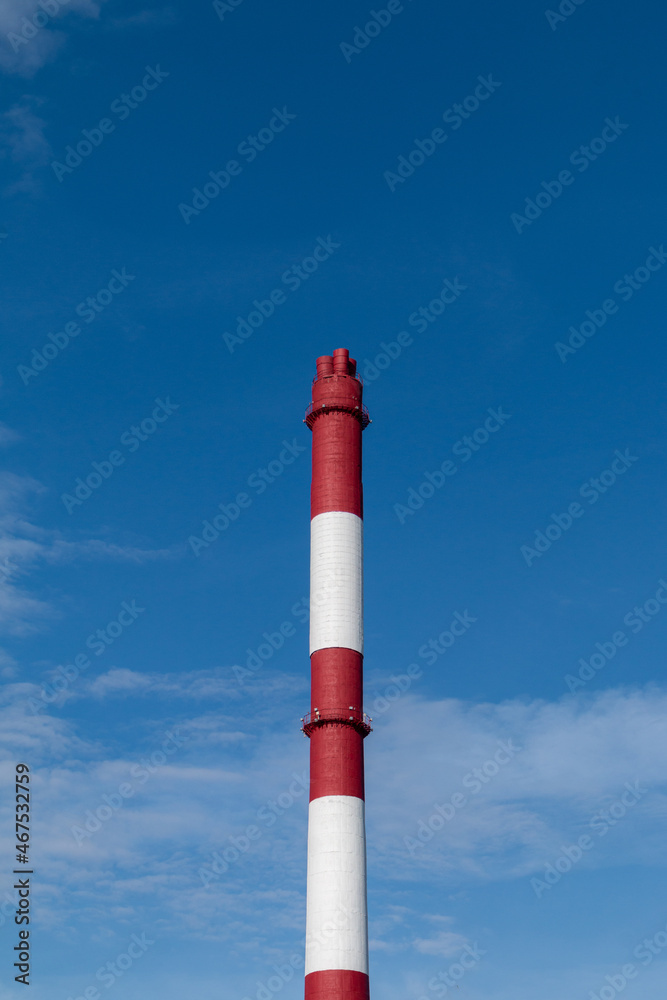 red and white chimney against blue sky. environment pollution concept red and white chimney against blue sky. environment pollution concept