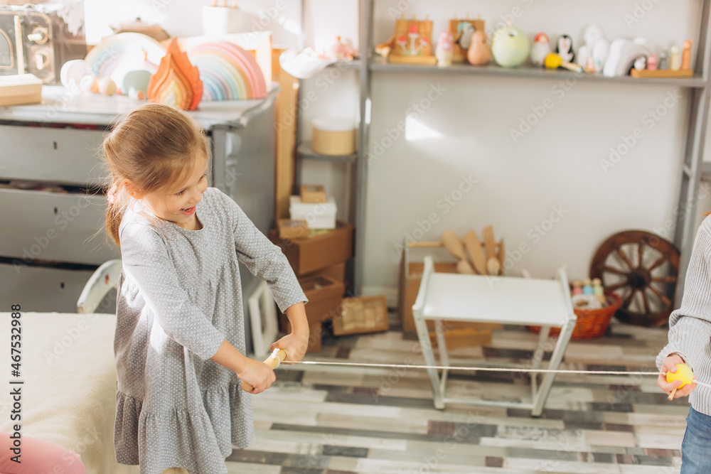 Happy smiling adorable girl playing together with wooden eco toys. Friendship,children activity Happy smiling adorable girl playing together with wooden eco toys. Friendship,children activity