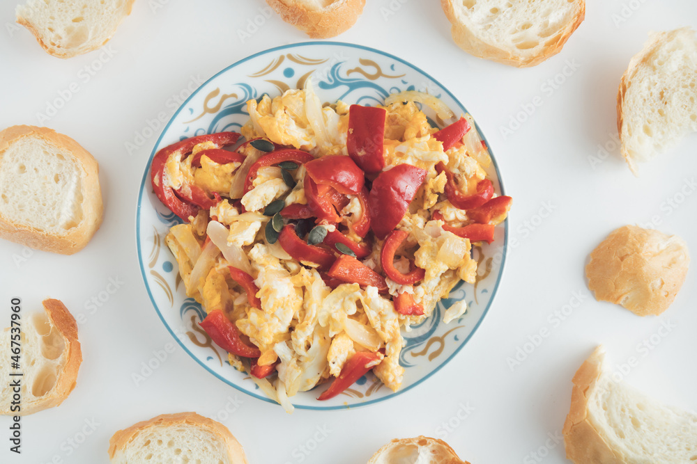Peppers and Onions Scrambled Eggs with bread on a light background. The natural and healthy breakfast on my desk. Top view. Flat lay.