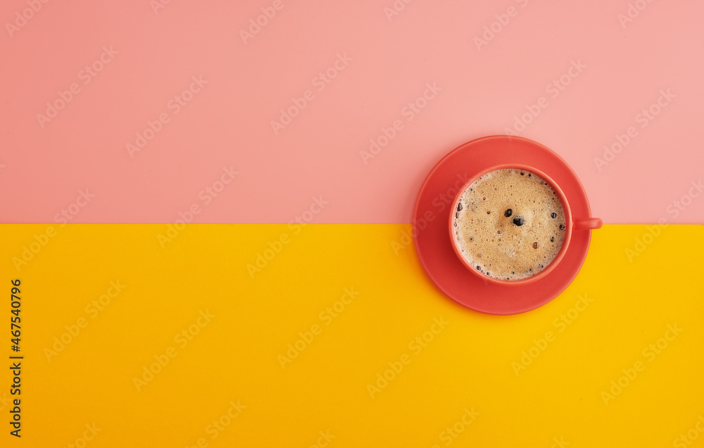 Top view of a cup of coffee on orange pastel background Top view of a cup of coffee on orange pastel background