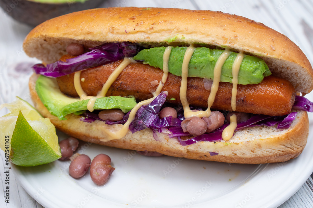 Vegan hot dogs made with carrot served in buns with beans, avocado and pickles Vegan hot dogs made with carrot served in buns with beans, avocado and pickles