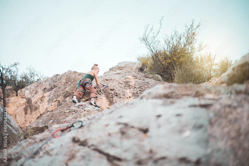 a girl climbing a rock in the open air.