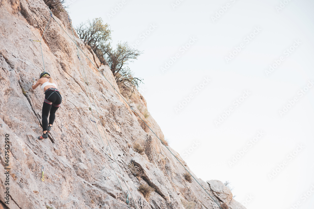 a girl climbing a rock in the open air.