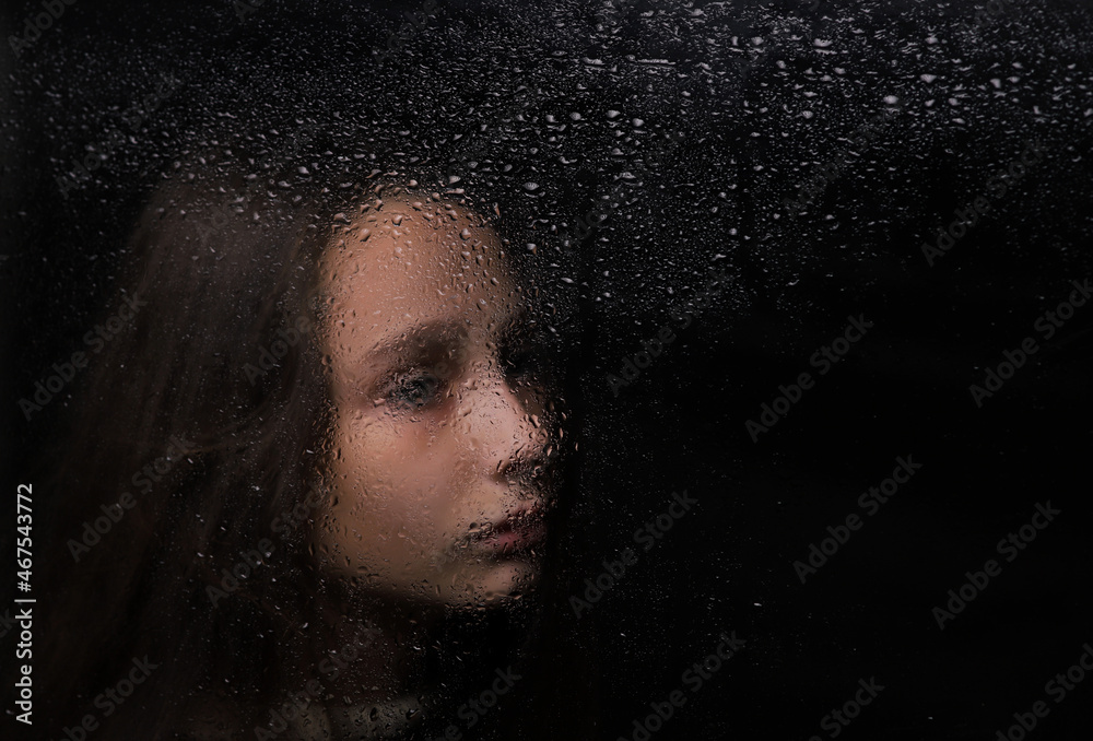 portrait of a girl with a reflection on a dark background by the window