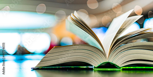 Konstfotografi An open hardcover book on a table in a public library