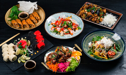 Asian food cooking. Wok, noodles and vegetables salad and chopsticks on dark rustic background