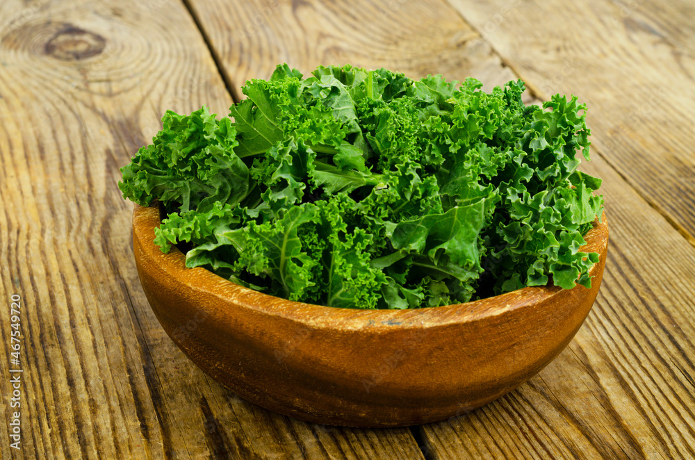 Fresh green sabellica leaves on wooden background, healthy organic food. Fresh green sabellica leaves on wooden background, healthy organic food.