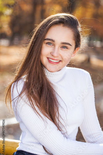  young brunette girl posing in autumn park