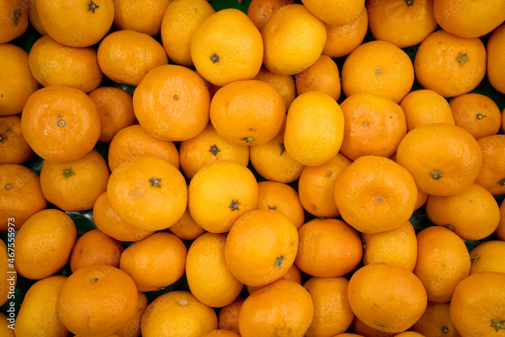 Tangerine background. Citrus fruit. Natural remedy for colds. Vegetarian food. Fresh mandarin oranges fruit or tangerines with leaves, as background. Tangerine background. Citrus fruit. Natural remedy for colds. Vegetarian food. Fresh mandarin oranges fruit or tangerines with leaves, as background.