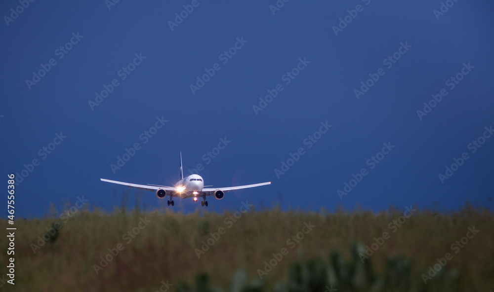 Night flight. The plane lands on the runway. Dust. Dark sky. Copy space. Flights. Airport background