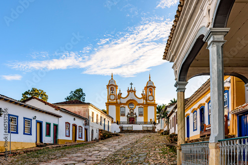 A quiet historic street in the city of Tiradentes in Minas Gerais with colonial houses and a baroque church in the background