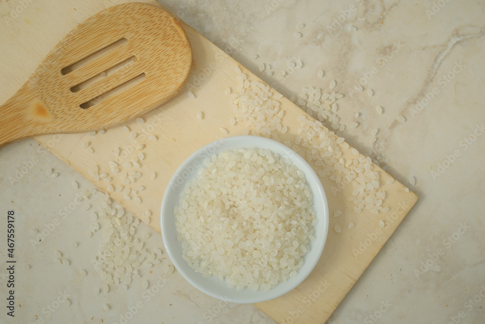 Rice on a plate with wooden spoon in a kitchen top Rice on a plate with wooden spoon in a kitchen top