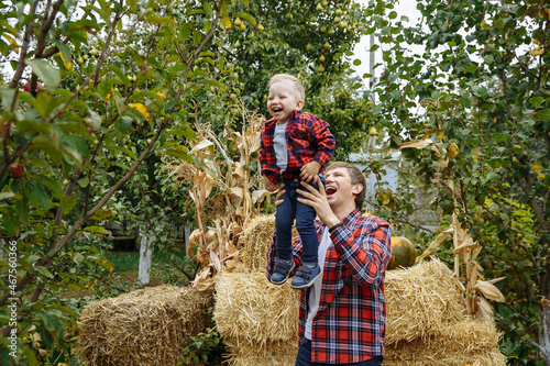 dad plays with his son on the background of hay in the countryside