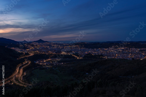 view of the city of Bilbao at sunset from a nearby mountain