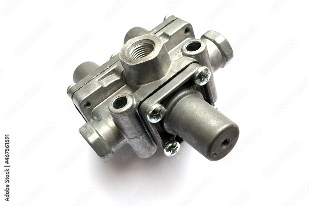 Protective valve of the triple pneumatic brake system of the truck on a white background. New spare parts. Protective valve of the triple pneumatic brake system of the truck on a white background. New spare parts.