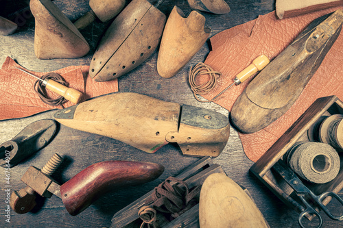 Antique shoemaker workshop with tools, strap, leather and rules.
