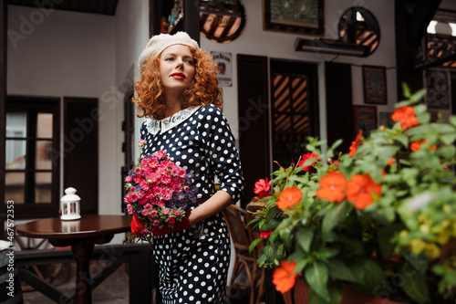 Photography Woman portrait in a beret and blue dress holding a bouquet of flowers of the res