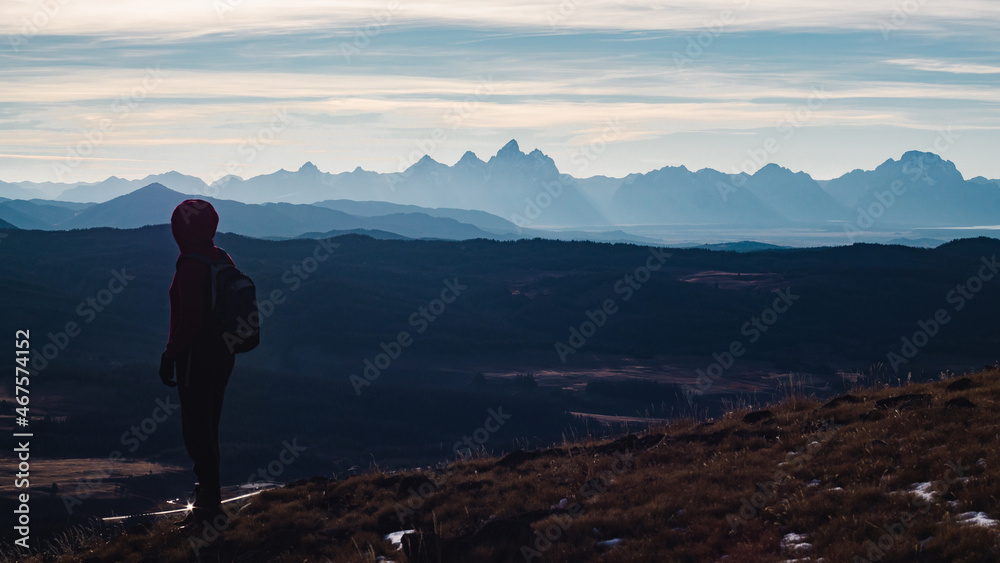 woman looking out over landscape from mountaintop woman looking out over landscape from mountaintop