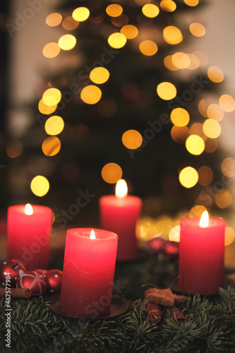 Adventskranz mit Kerzen und Weihnachtsbaum im Hintergrund © Philip