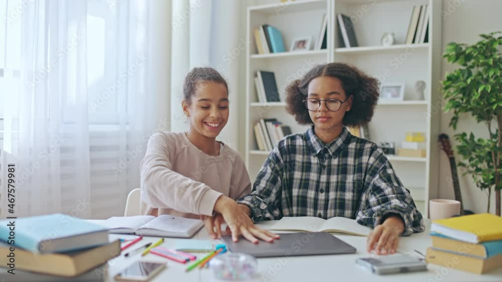 Glad female friends giving high five, closing laptop, finishing school task Glad female friends giving high five, closing laptop, finishing school task