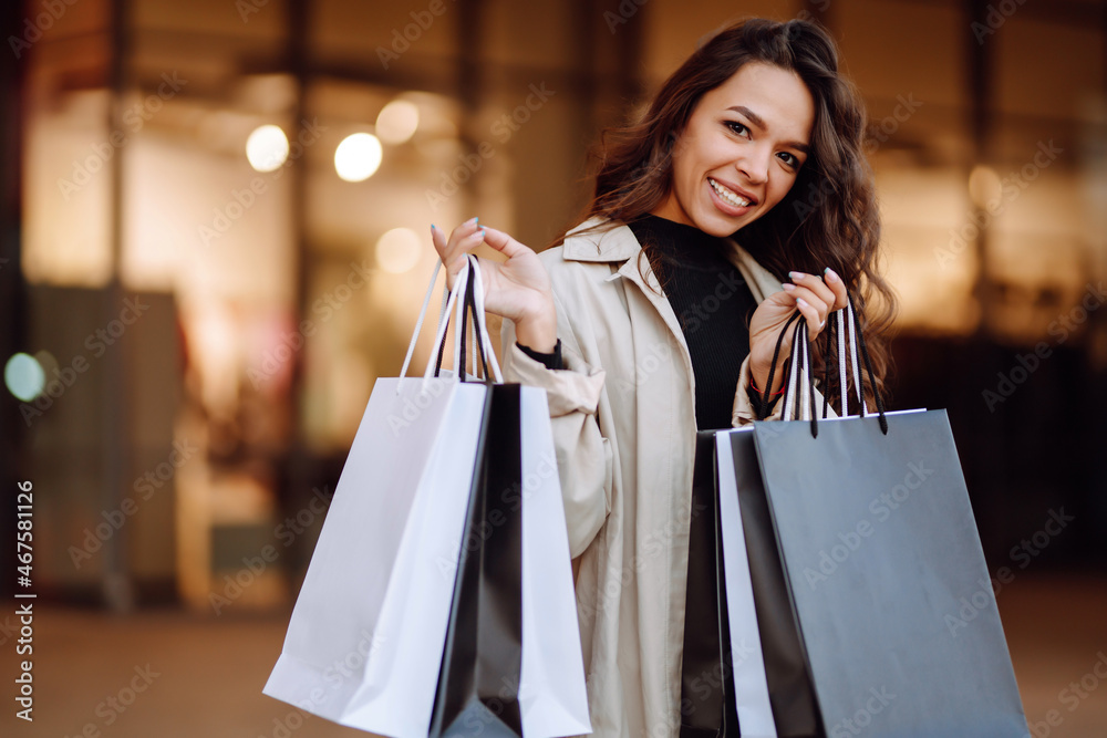 Afro American woman with shopping bags near mall. Black friday. Consumerism, sale, discounts, lifestyle concept. Afro American woman with shopping bags near mall. Black friday. Consumerism, sale, discounts, lifestyle concept.