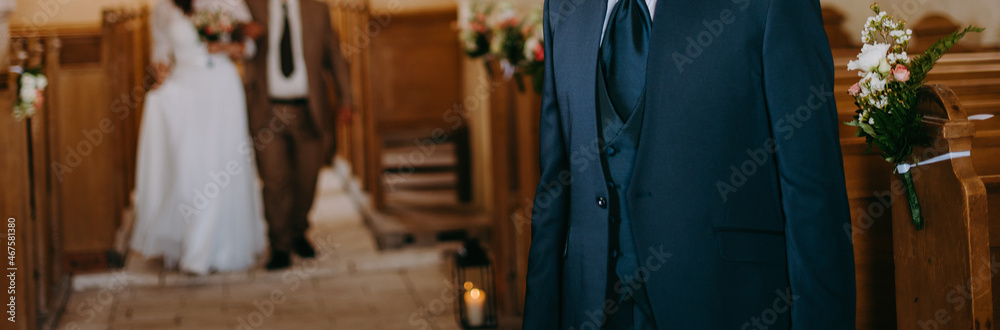 Young bride with her father walking towards the groom in a church