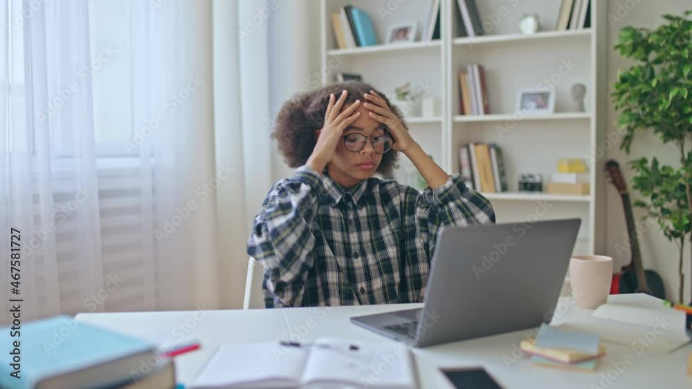 Upset school pupil reading bad news on laptop, low marks in exam, disappointment Upset school pupil reading bad news on laptop, low marks in exam, disappointment