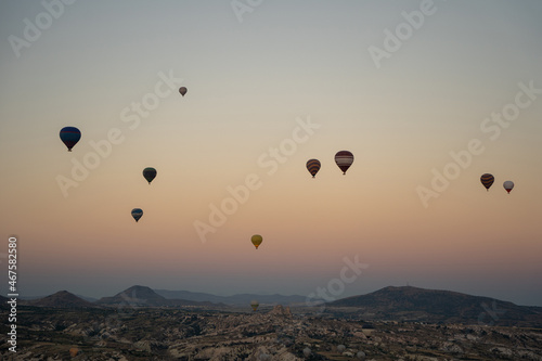 Beautiful panoramic nature landscape of countryside mountains with colorful high hot air balloons in summer sky. Vacation travel panorama background