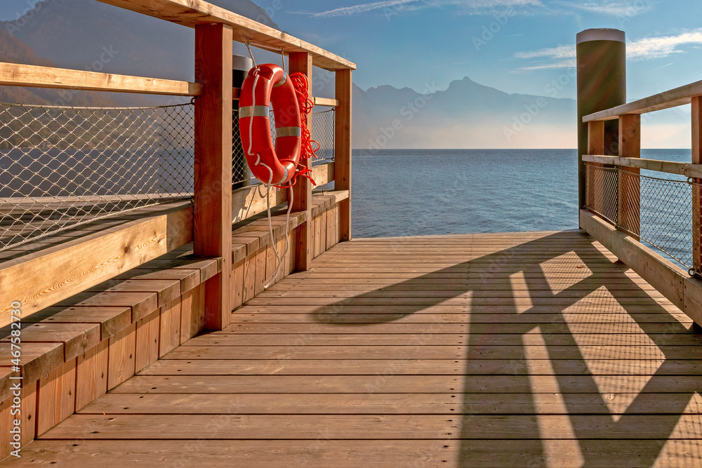 lifebuoy attached to a wooden pier, evening landscape