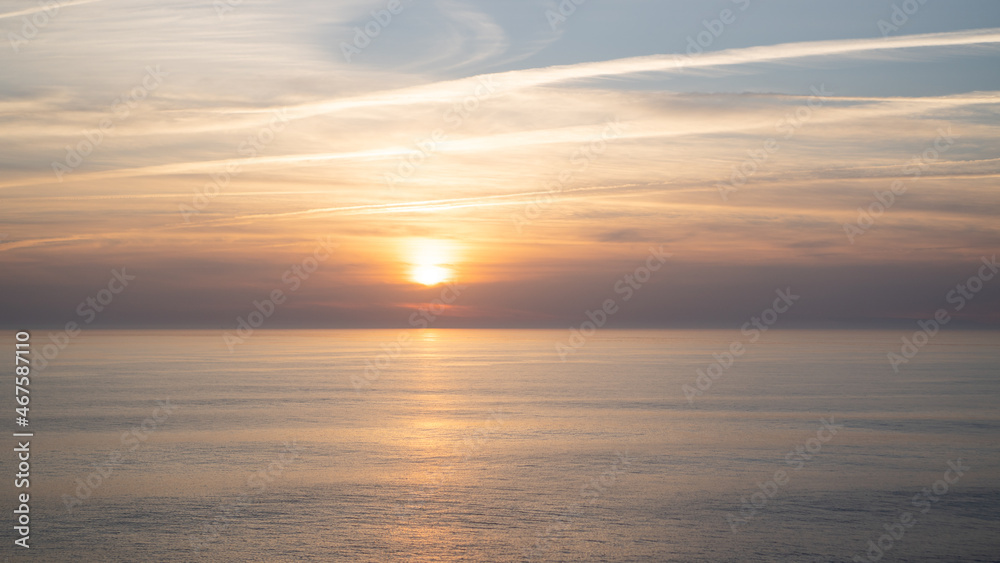 Portugal ocean sunset. Portuguese sky and sea. Pastel sunset with lines from airplanes. Airplane trails on sunset Portugal ocean sunset. Portuguese sky and sea. Pastel sunset with lines from airplanes. Airplane trails on sunset