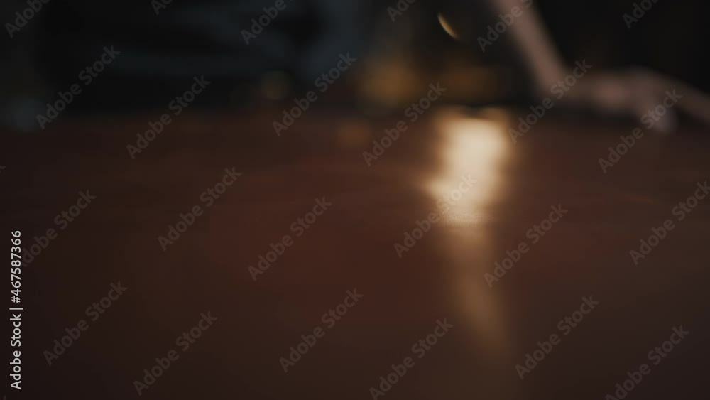 Tracking shot of male tailor hand smoothing leather piece on table at workshop, close up