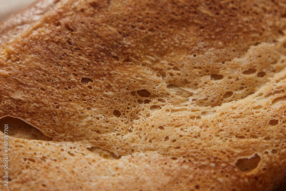 Fresh crusty bread with a golden crust up close. Background, texture.