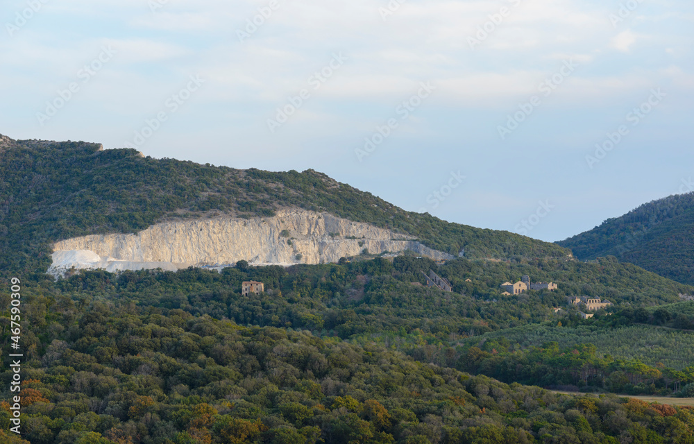 Tuscan hilly landscape defaced by a quarry with an abandoned mine