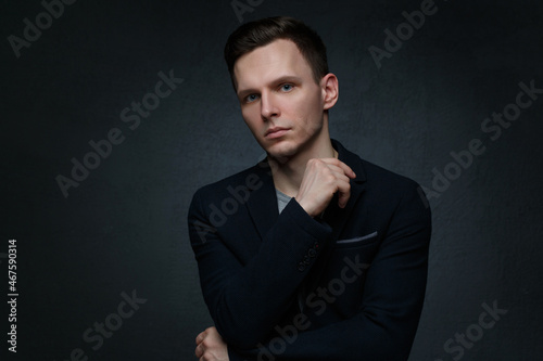 Portrait of a handsome business man in a suit on a dark background.