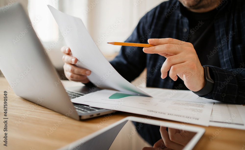 The company's financial report for the month. Workplace in the office. Working with documents and online spreadsheets. The man counts the company's revenue. The company's financial report for the month. Workplace in the office. Working with documents and online spreadsheets. The man counts the company's revenue.