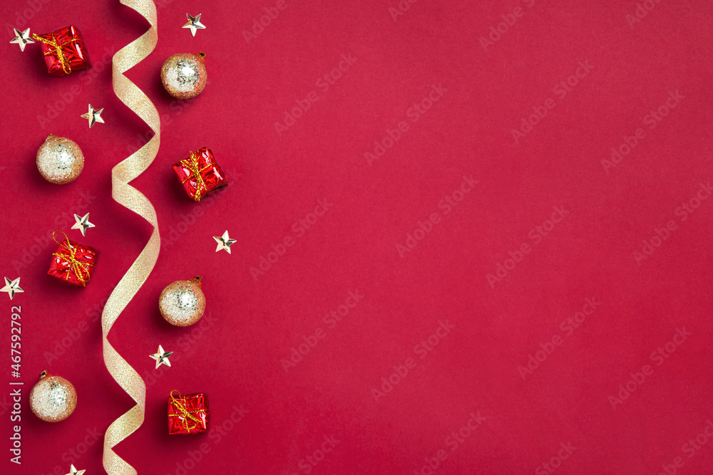 New Year or Christmas border or background with golden ribbon, golden balls, gifts and stars on red background, copy space. Mockup for postcards, business cards and other festive materials