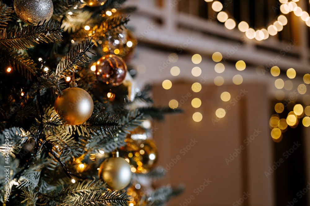A beautiful festive Christmas tree decorated with Christmas balloon toys in the evening. Close-up. A beautiful festive Christmas tree decorated with Christmas balloon toys in the evening. Close-up.