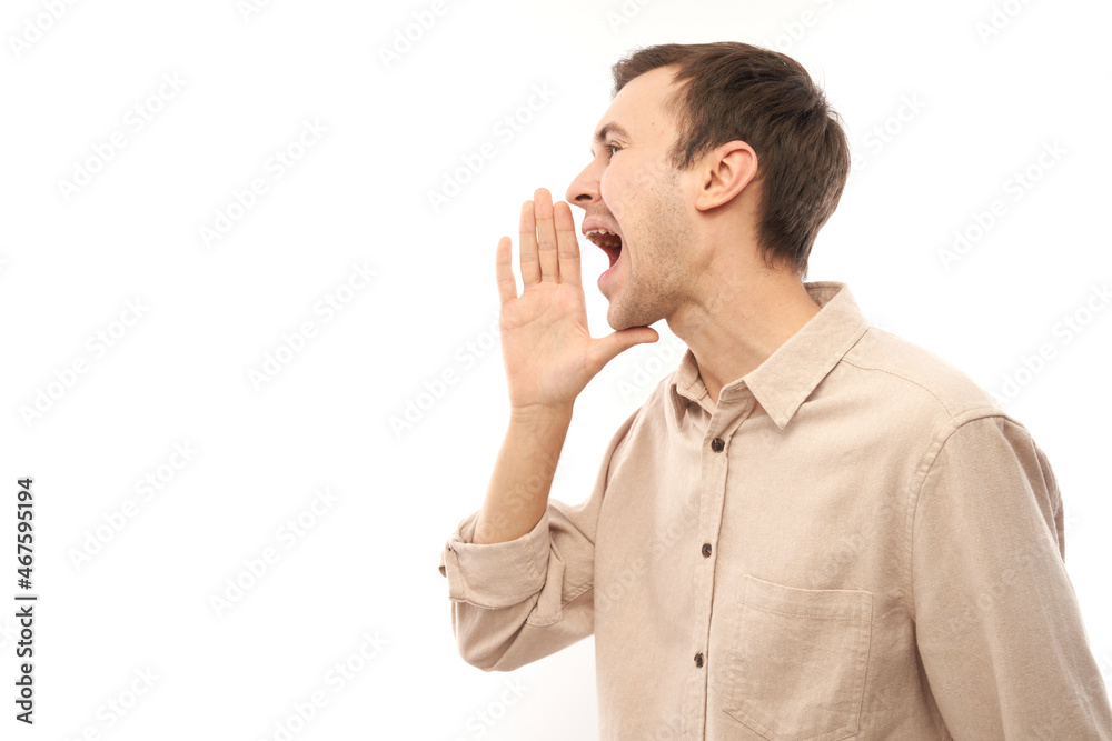 Handsome happy young caucasian male shouting and cupping hands around mouth isolated on white studio background. Excited news attention! Handsome happy young caucasian male shouting and cupping hands around mouth isolated on white studio background. Excited news attention!