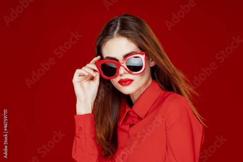 beautiful woman wearing sunglasses red shirt makeup isolated background