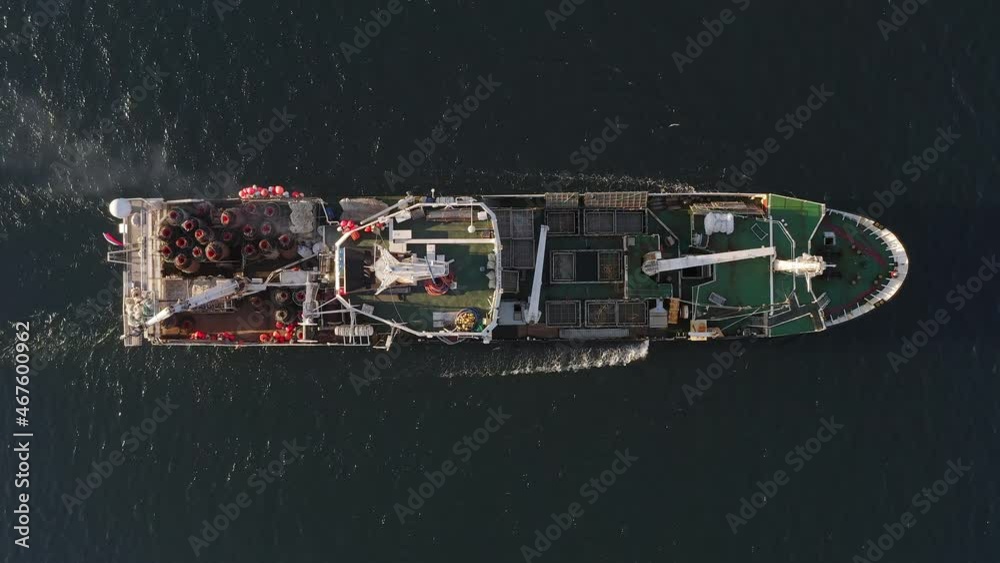 View from the drone vertically down on a fishing trawler at sea on the move
