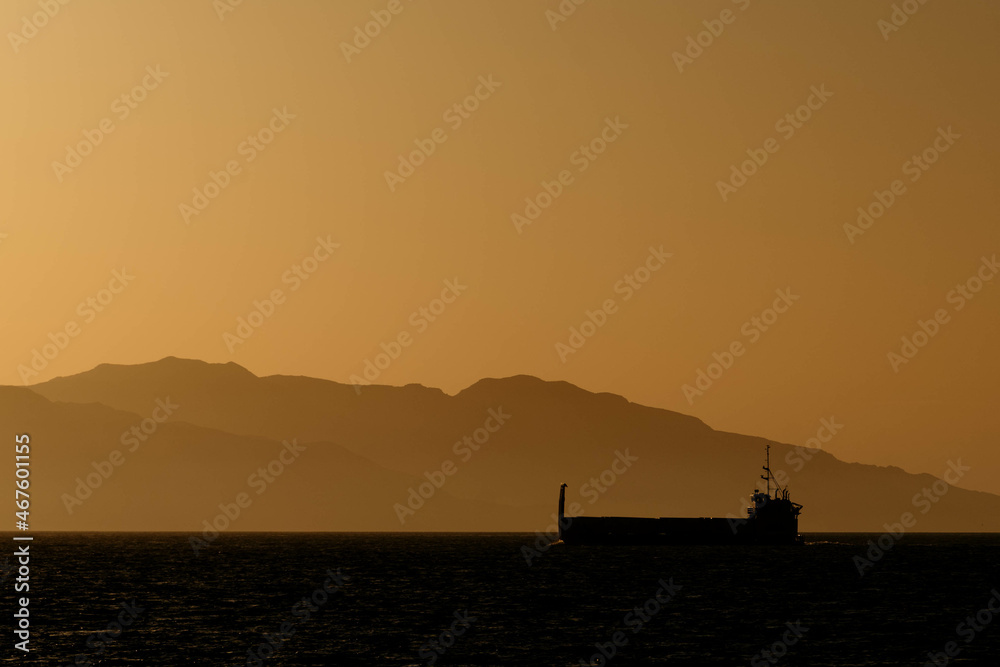 Cargo Ship at Sunset with Island in Background