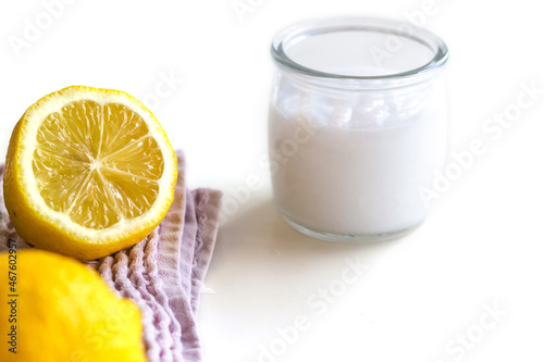 Cosmetic product for skin care. Lemons are lying on the towel to the left, next to a glass jar with cream. Space for text. Concept: cosmetology, spa, healthy nutrition, medicine, vitamins.