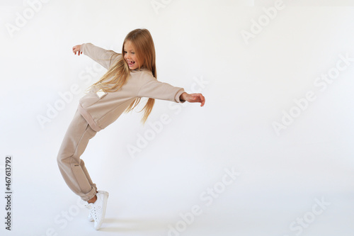 Girl dancing and laughing in a beige suit