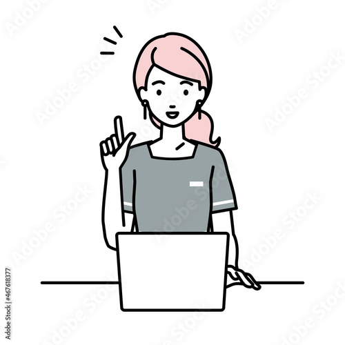 デスクで座ってPCを開いて何かひらめいたエステ店員の女性