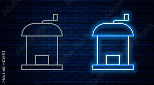 Glowing neon line Manual coffee grinder icon isolated on brick wall background. Vector