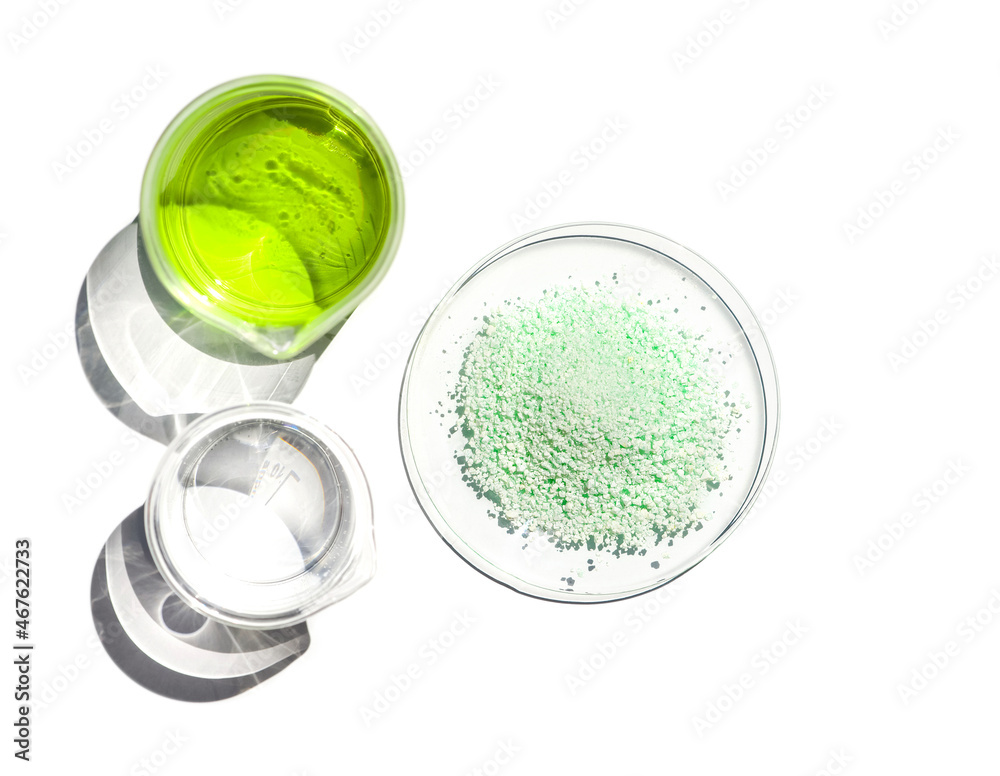 Ferrous Sulfate in Chemical Watch Glass place next to Iron (II) sulfate liquid in Beaker. Close up chemical ingredient on white laboratory table. Top View Ferrous Sulfate in Chemical Watch Glass place next to Iron (II) sulfate liquid in Beaker. Close up chemical ingredient on white laboratory table. Top View