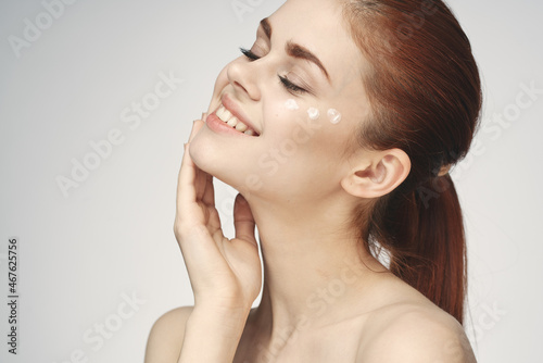 woman with bare shoulders face cream skin care close-up