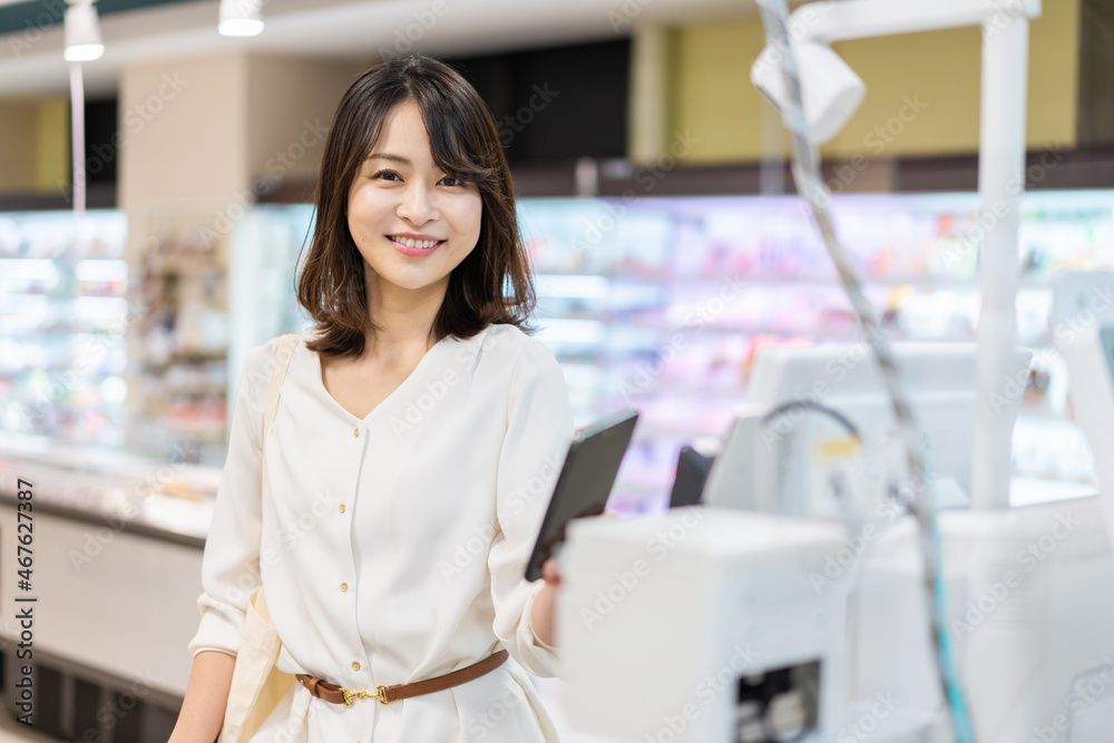 セルフレジ・電子マネー決済をする若い女性 セルフレジ・電子マネー決済をする若い女性