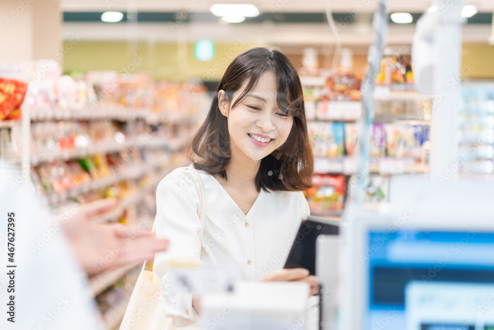 セルフレジ・電子マネー決済をする若い女性